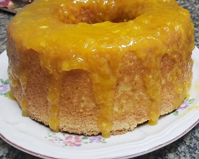 Bolo caseiro de laranja com calda escorrendo pelas laterais